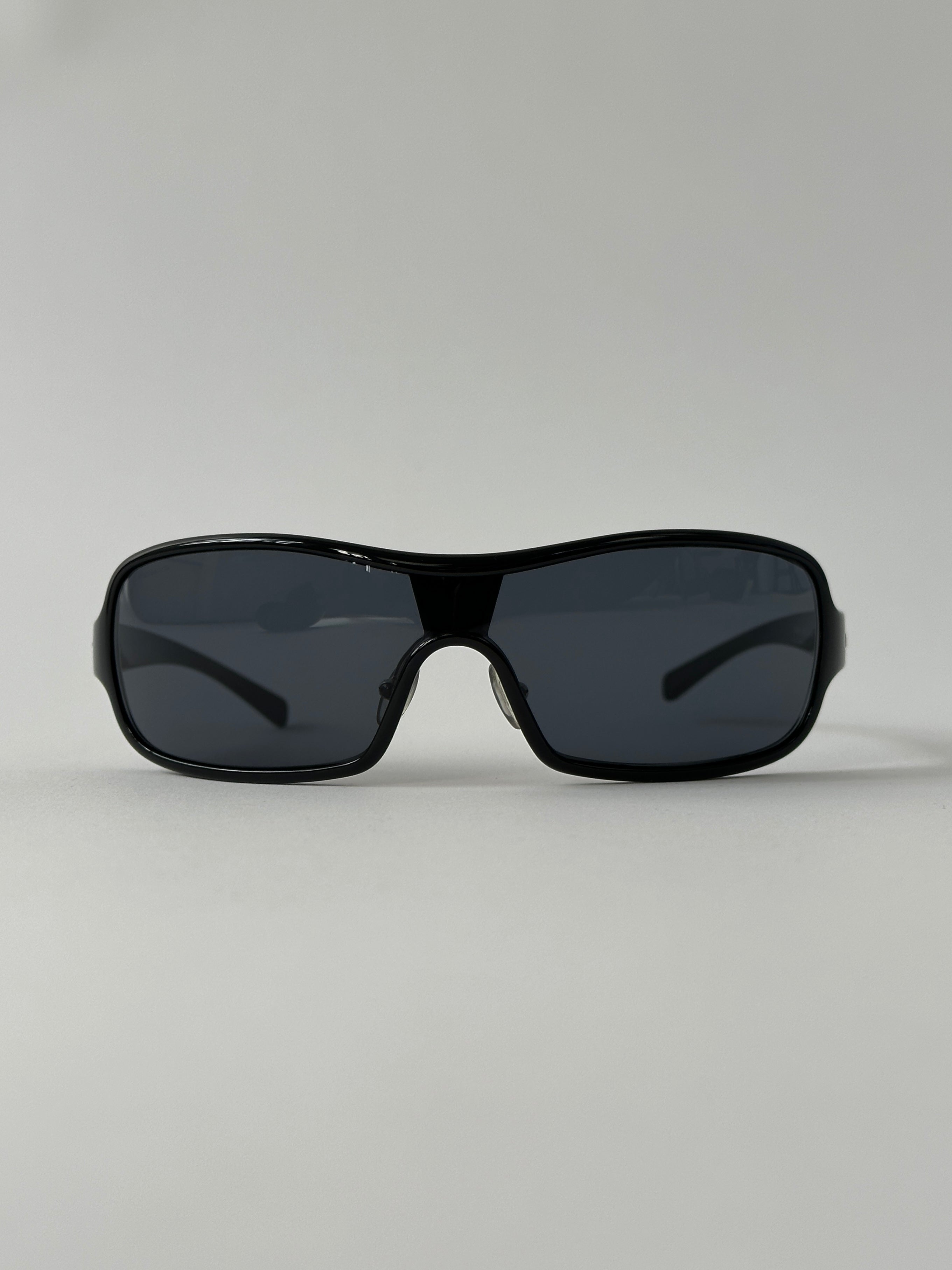 Prada 2000s Shield Sunglasses with bold black frames and dark tinted lenses, stylish and iconic eyewear accessory.