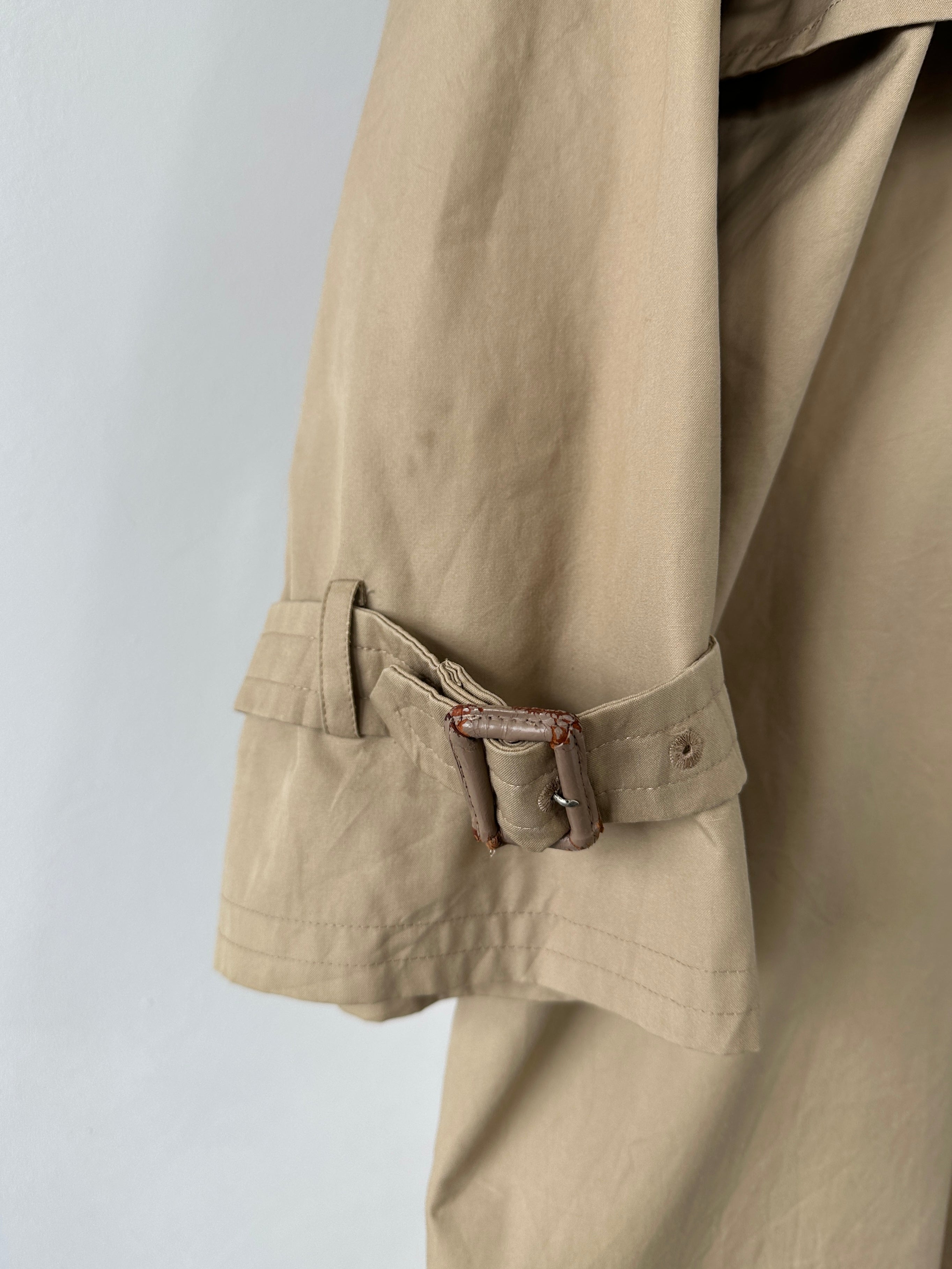 Yves Saint Laurent Paris double-breasted trench coat in size M, shown on a hanger with classic beige fabric and tailored design.