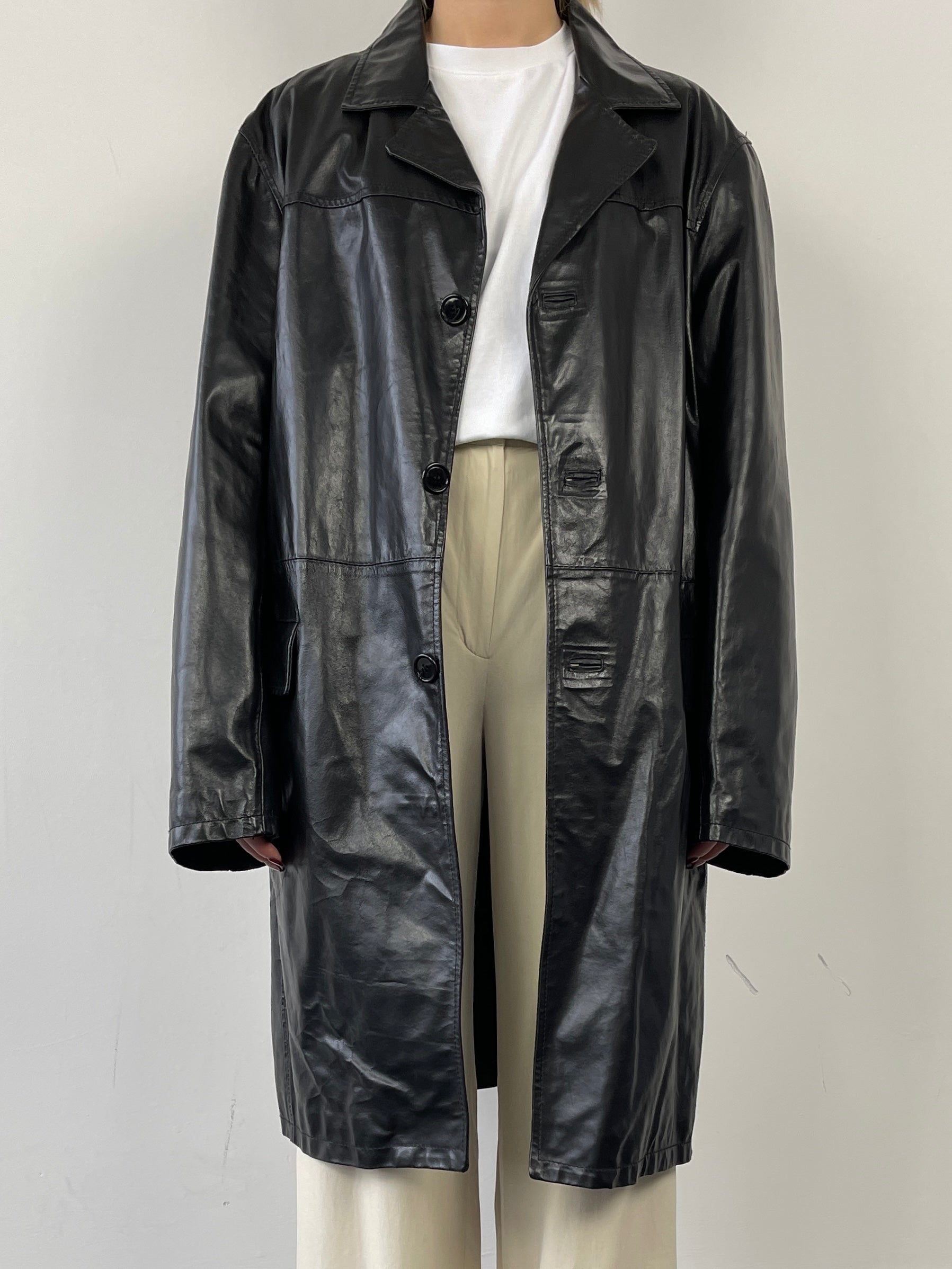 Vintage Italian leather trench coat jacket with classic design and aged leather finish, shown hanging on a wooden hanger.