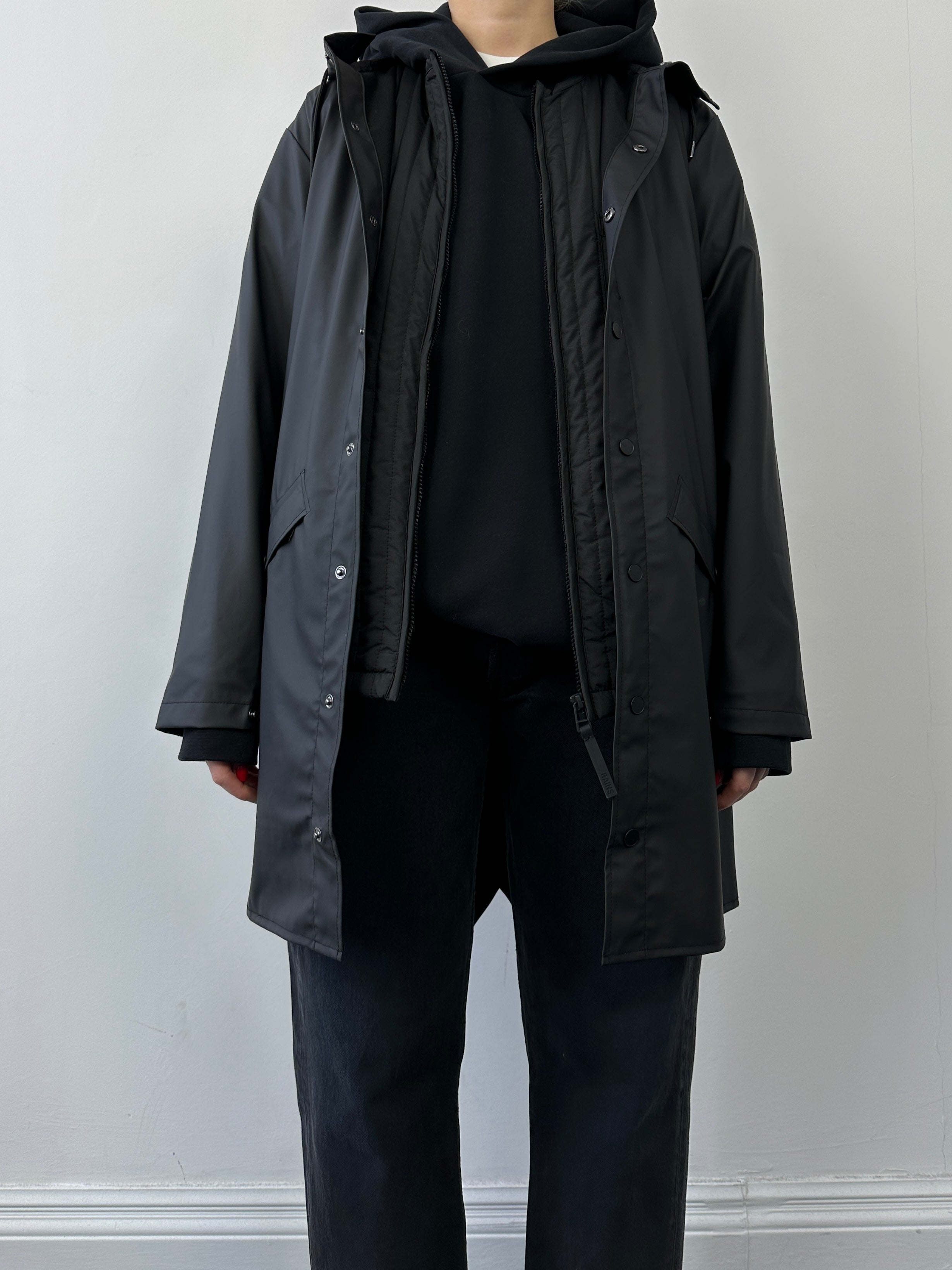 Rains waterproof zip-up liner vest gilet in sleek black, featuring a high collar and lightweight design for rain protection.