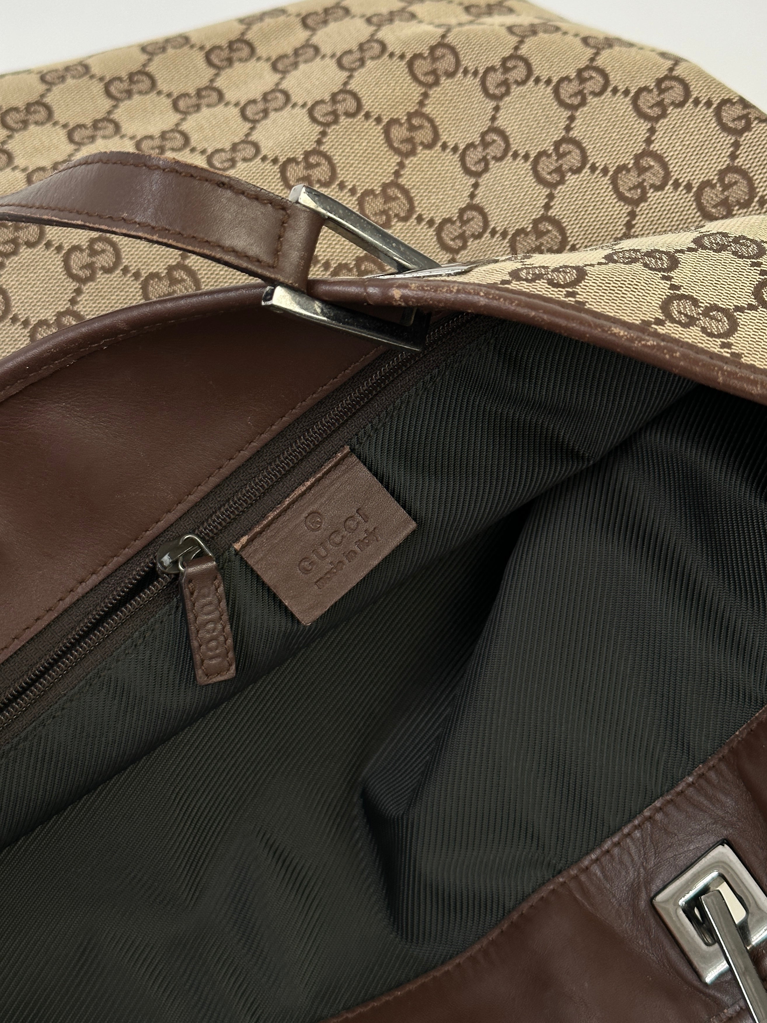 Gucci Monogram GG bucket tote bag with leather trim and adjustable shoulder strap, featuring signature monogram pattern.