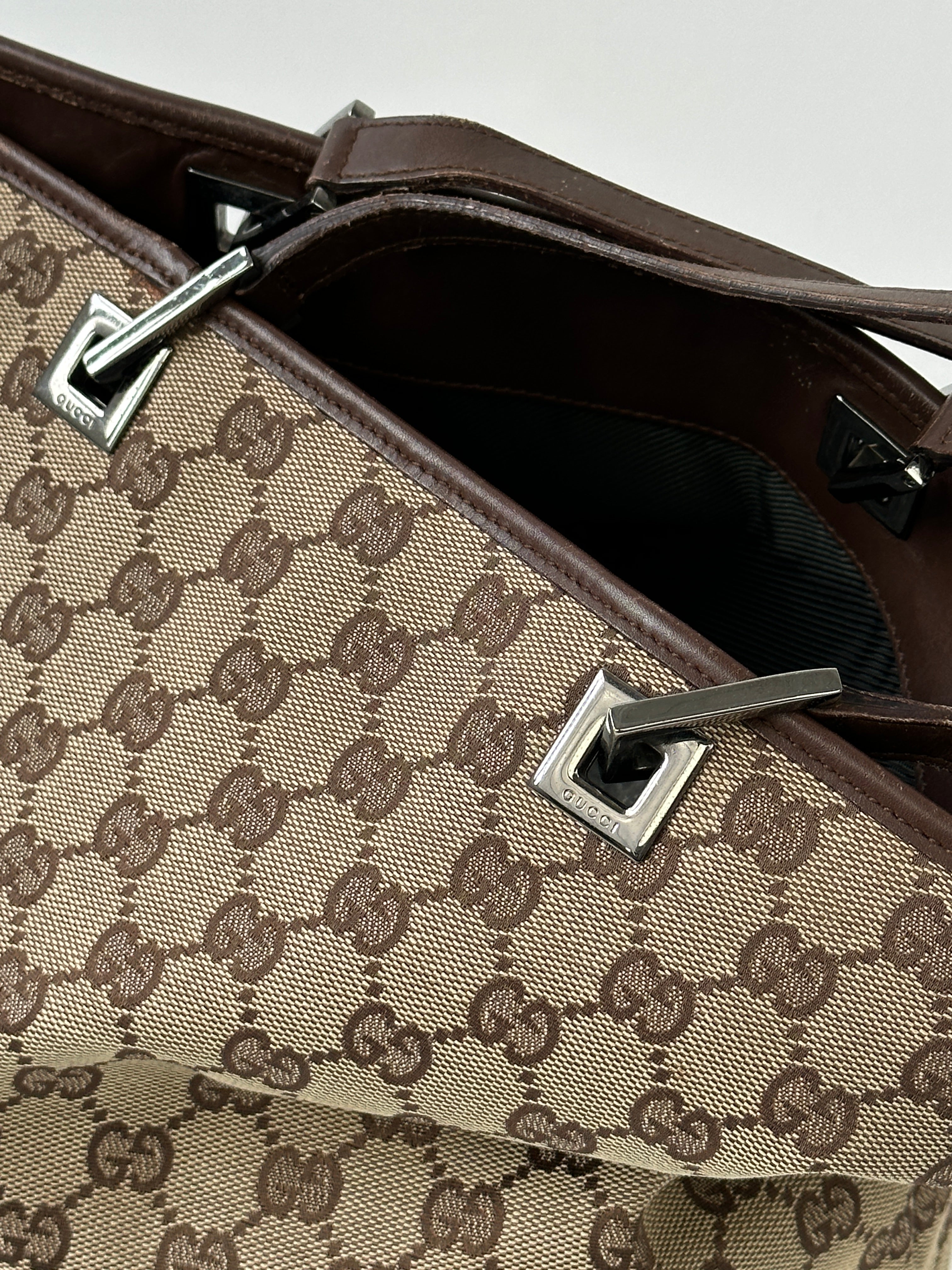 Gucci Monogram GG bucket tote bag with leather trim and adjustable shoulder strap, featuring iconic Gucci monogram pattern.