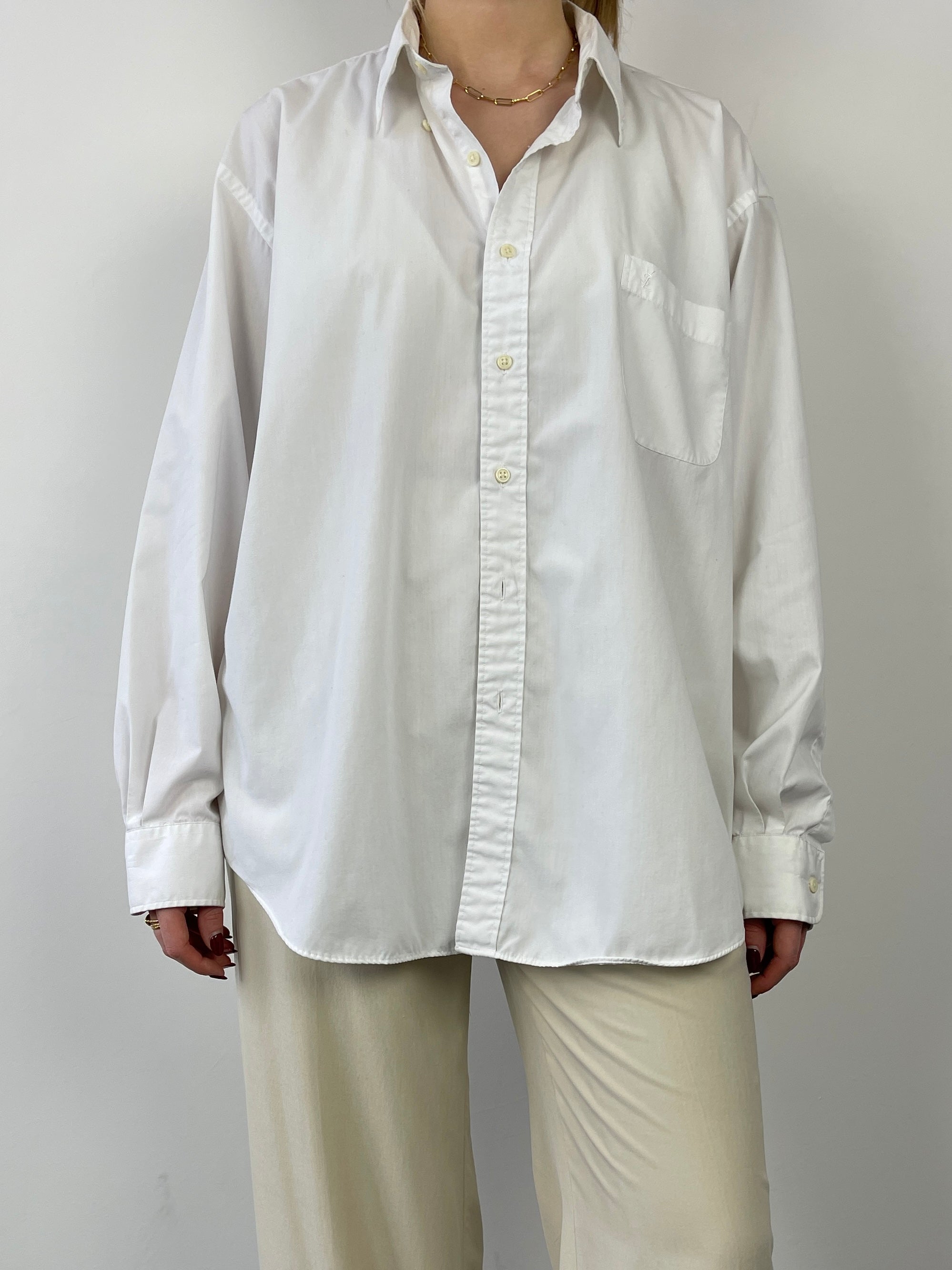 Yves Saint Laurent cotton shirt shown in white, featuring a classic collar and button-down front, styled casually.