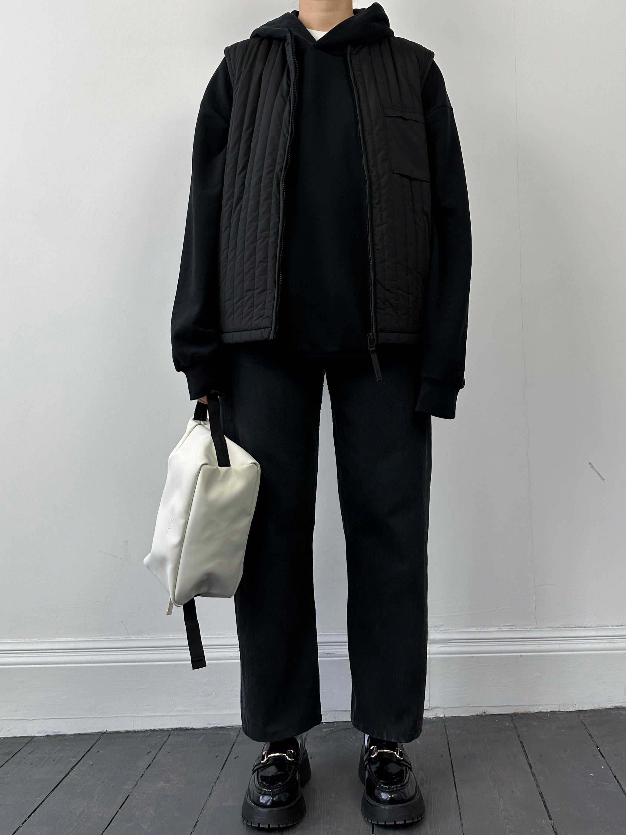 Rains waterproof zip-up liner vest in sleek black, lightweight gilet with a high collar and front zipper for outdoor wear.