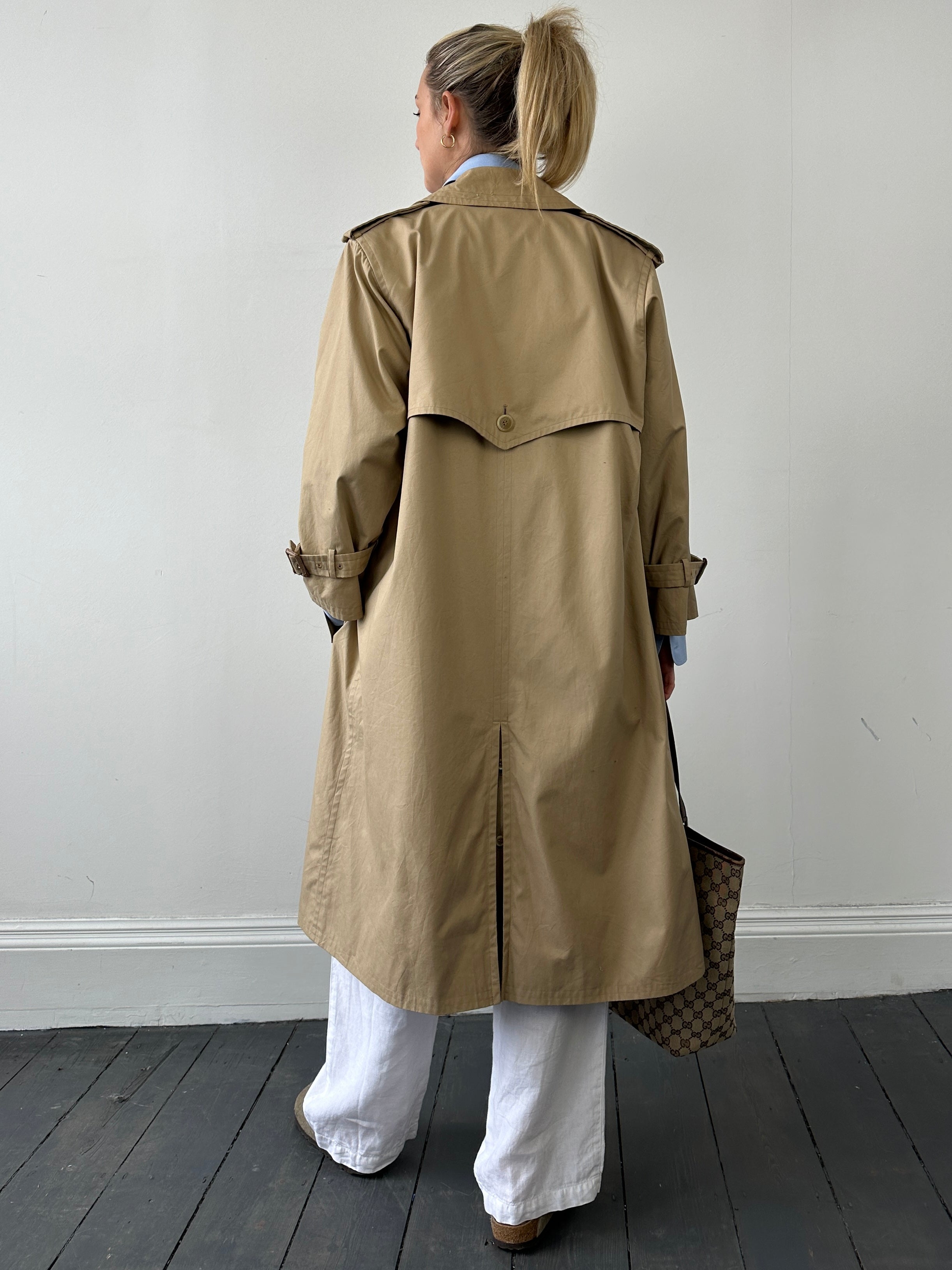 Yves Saint Laurent Paris double-breasted trench coat in size M, beige fabric with classic collar and button details.