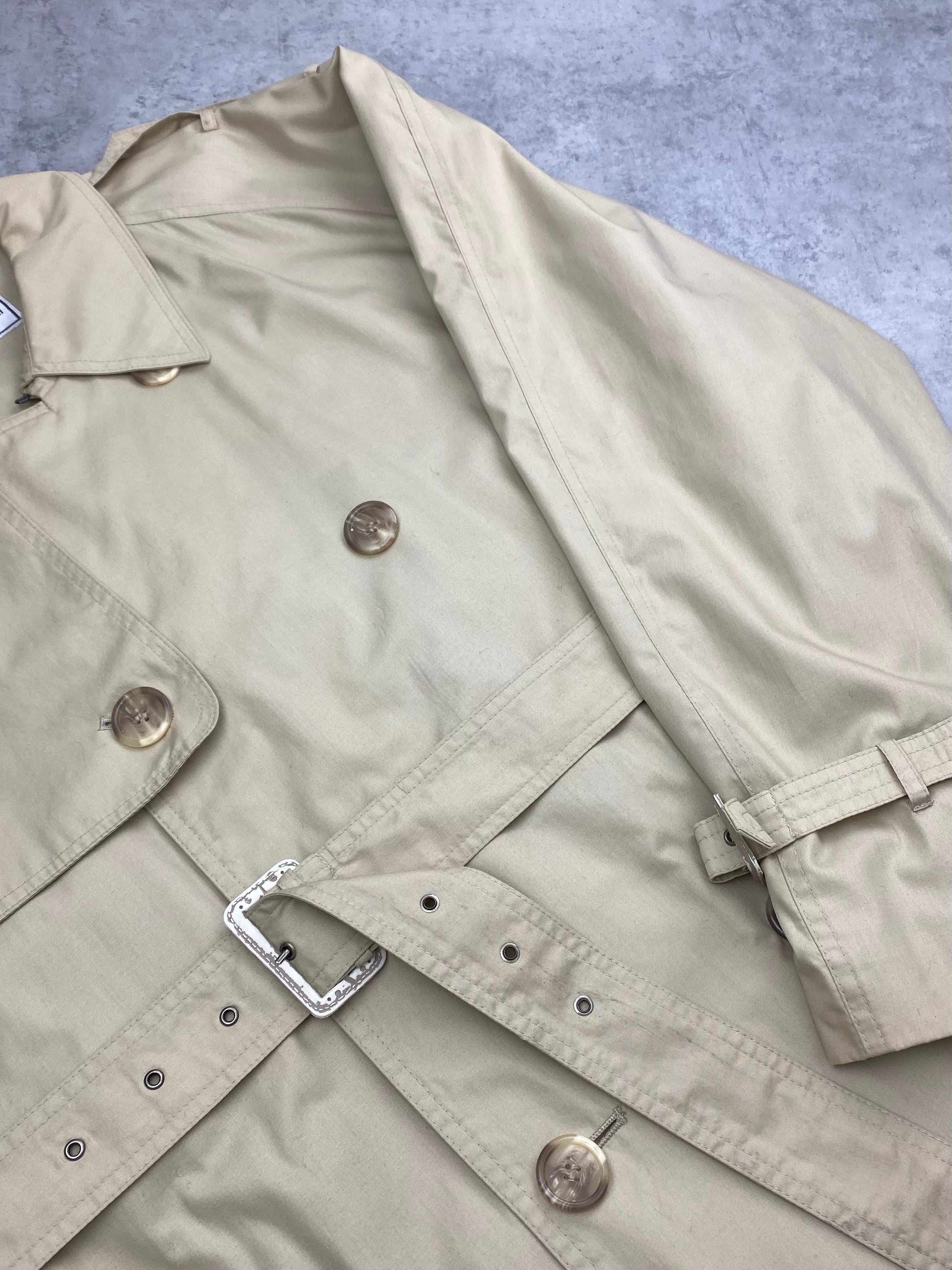 Yves Saint Laurent cotton trench coat displayed on a hanger, showcasing classic design and tailored fit.