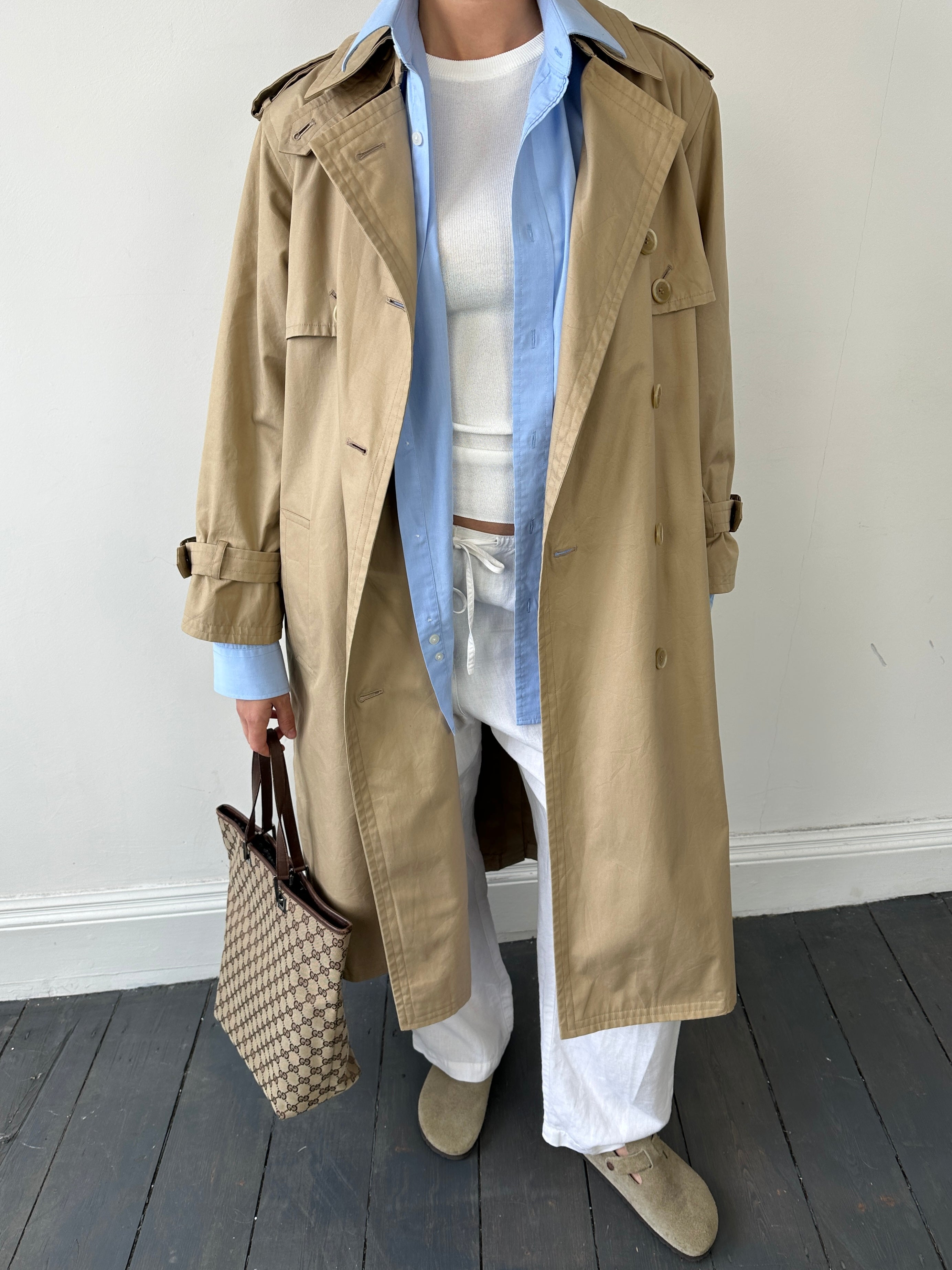 Yves Saint Laurent Paris double-breasted trench coat in size M, beige fabric with classic collar and belted waist.