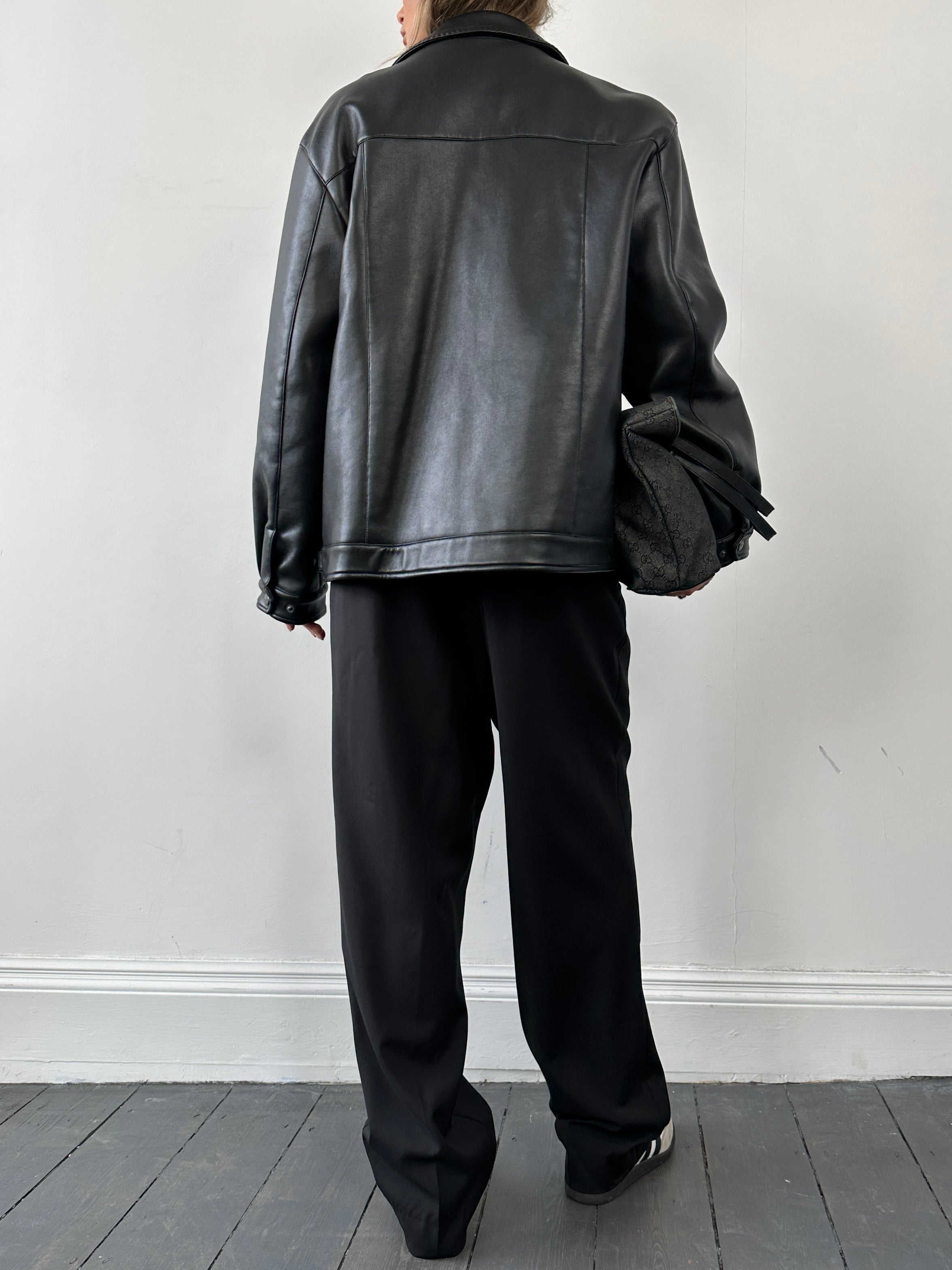 Vintage double zip faux leather jacket in M/L size with classic design and stylish details, shown on a hanger.
