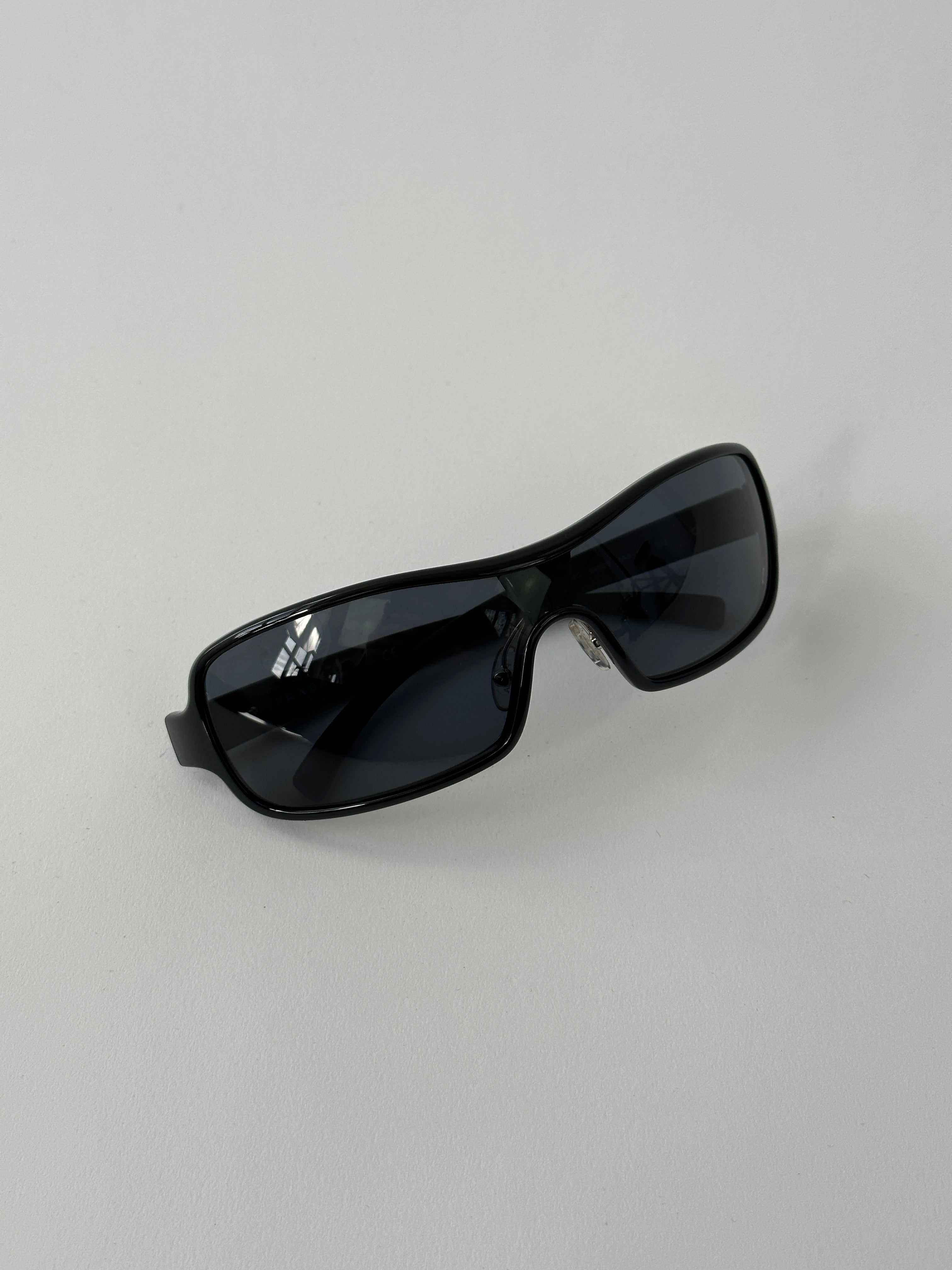 Prada 2000s shield sunglasses with dark tinted lenses and sleek black frames, stylish and iconic eyewear for bold fashion statements.