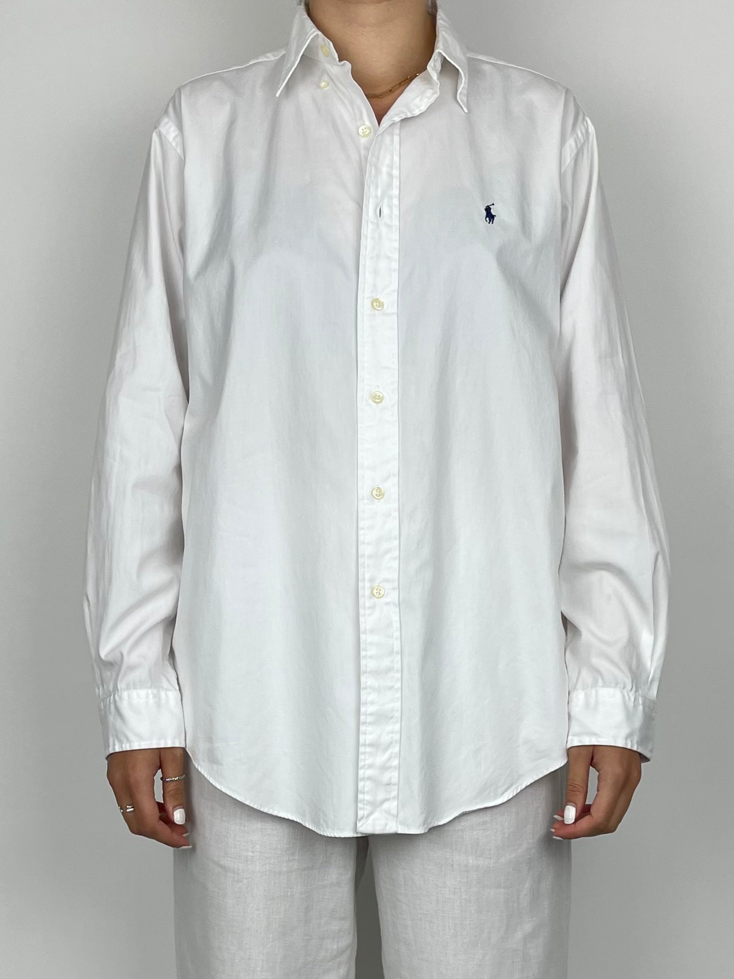 Ralph Lauren cotton shirt displayed flat, showcasing the classic design and crisp white fabric with button details.