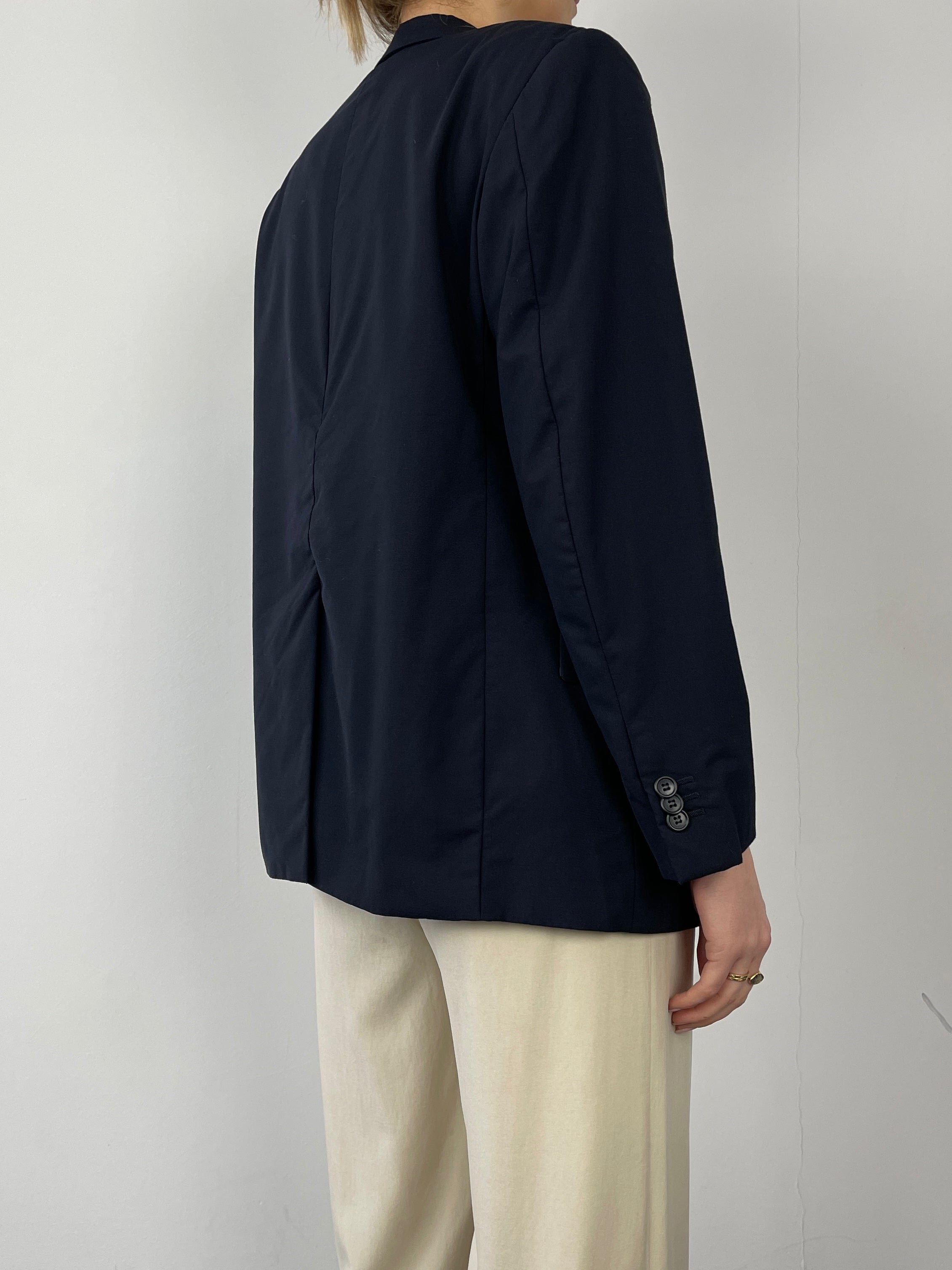Prada single-breasted tailored blazer in classic design with sleek lapels and structured fit, displayed on a neutral background.