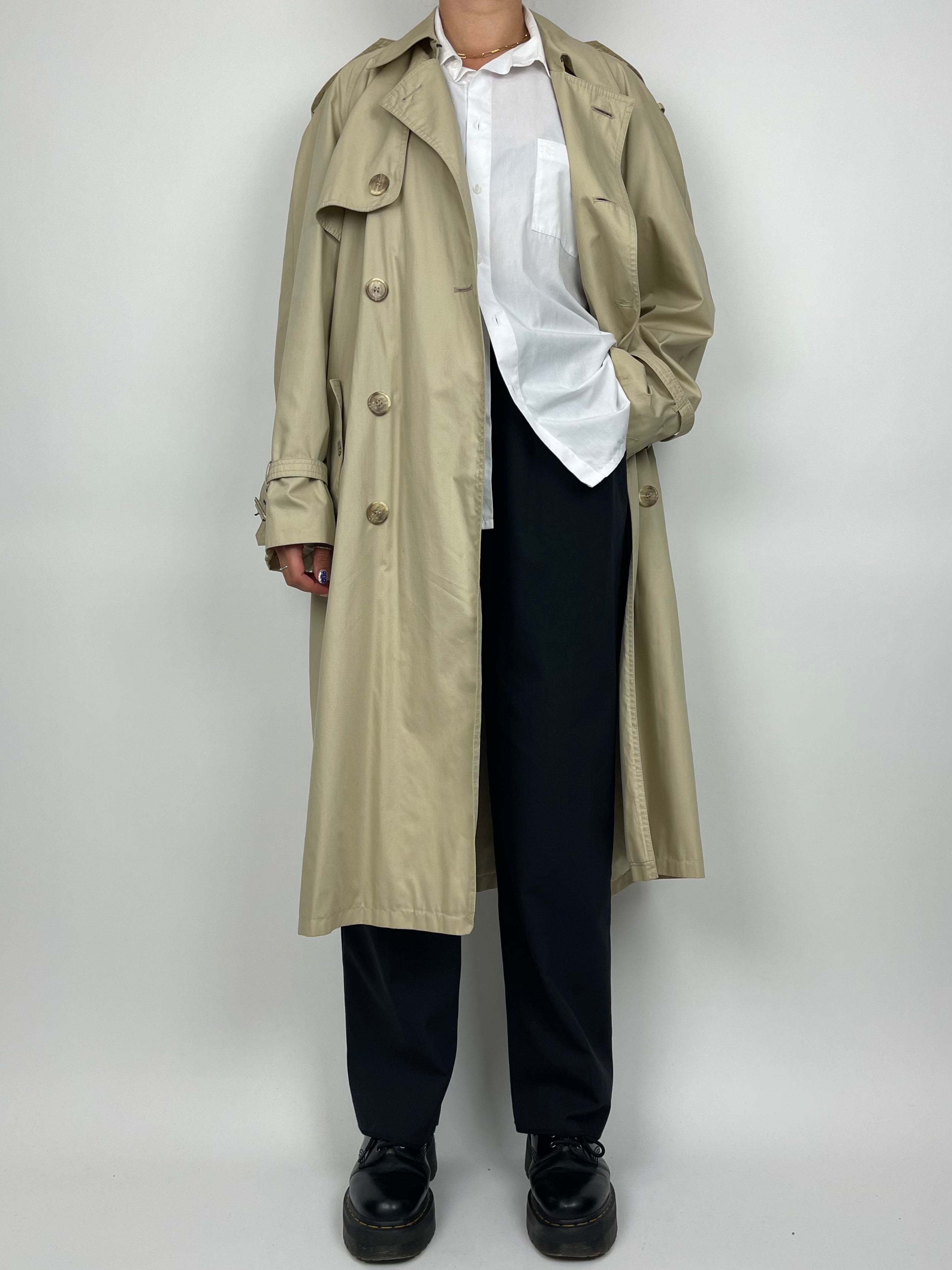 Yves Saint Laurent cotton trench coat displayed on a hanger, showcasing classic beige fabric and tailored design.