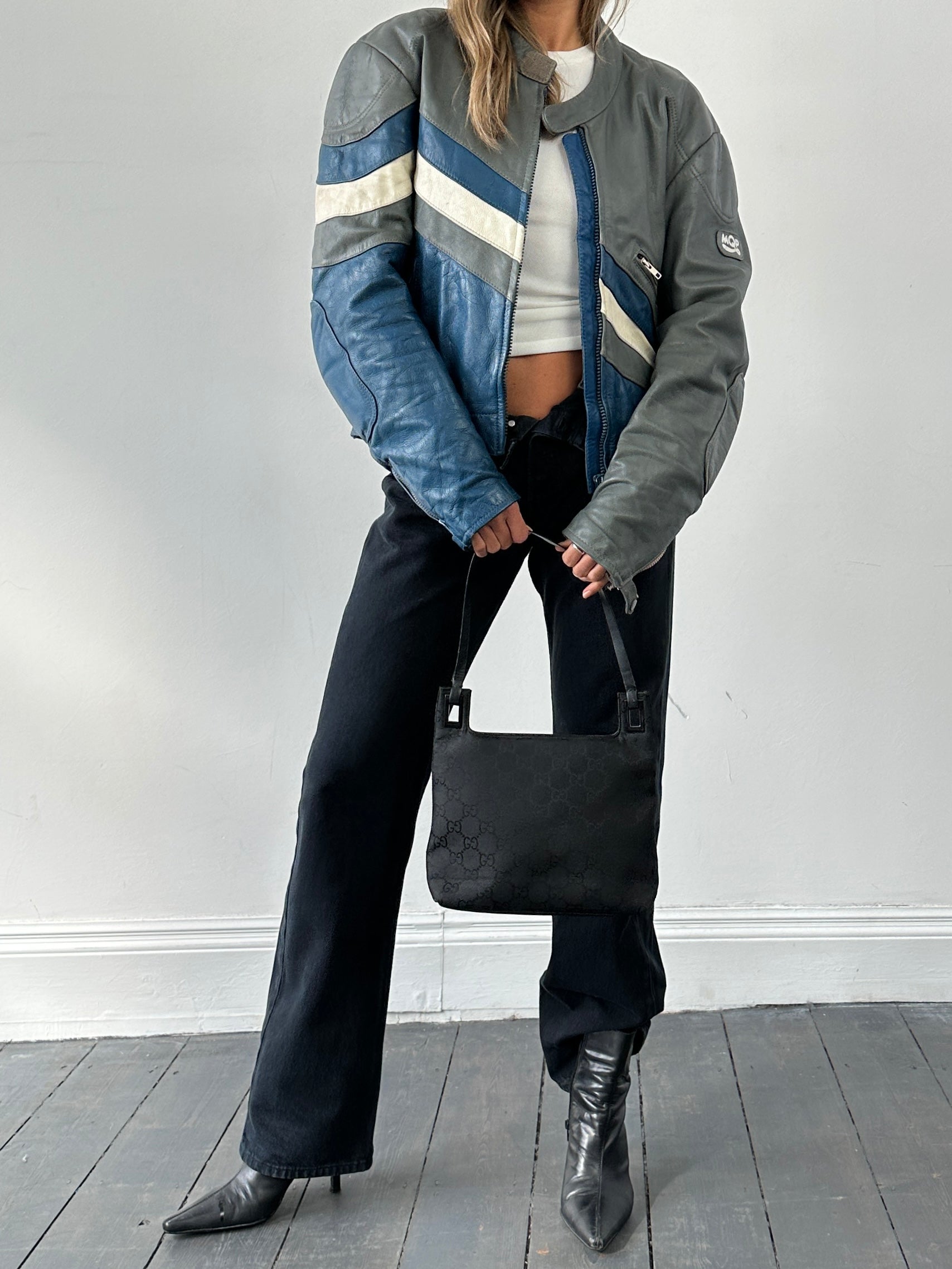 Vintage leather striped motorcycle jacket in size M/L, featuring classic design and durable material, displayed on a hanger.