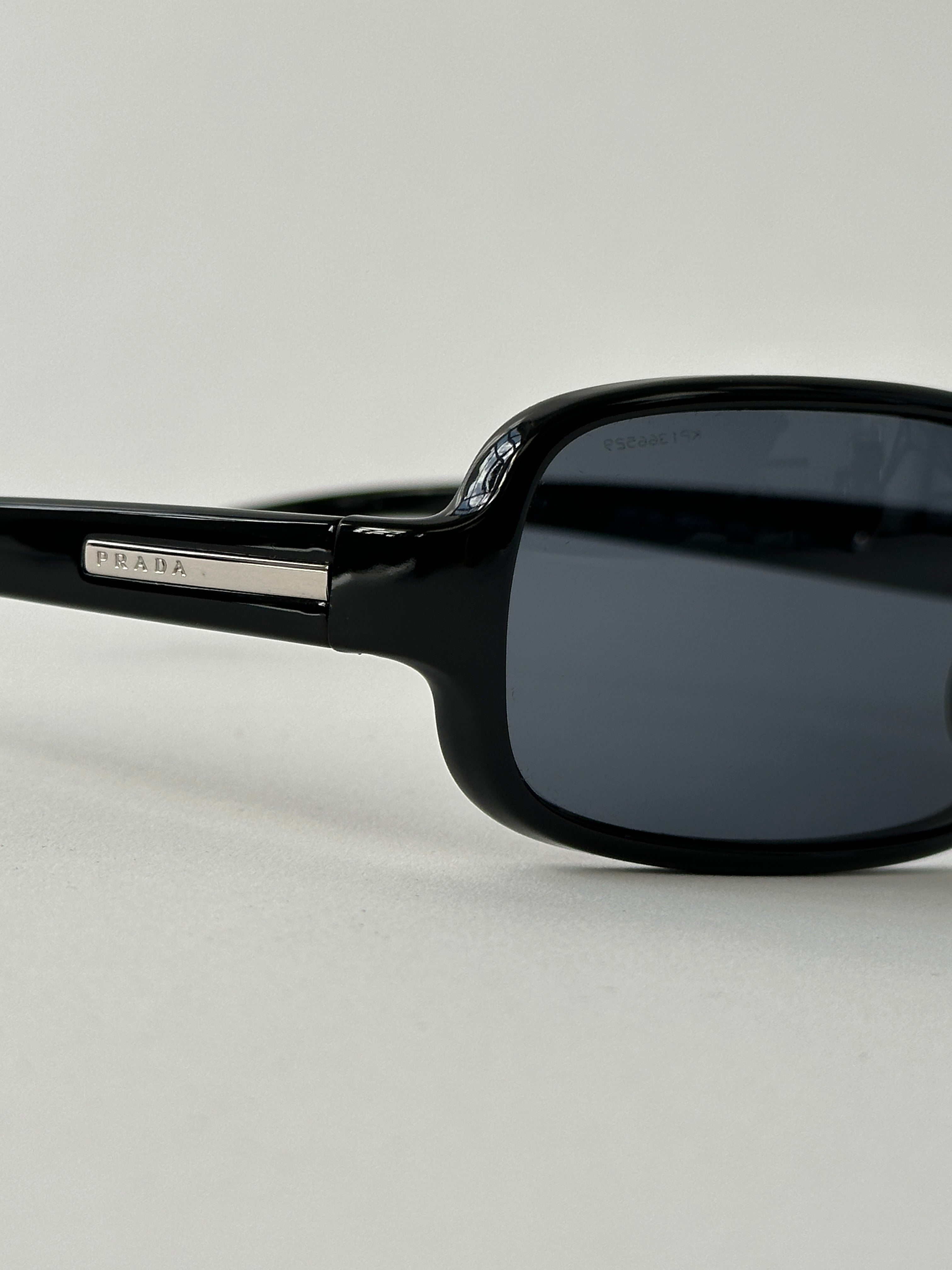 Prada 2000s Shield Sunglasses with bold black frames and dark tinted lenses, stylish eyewear for a modern look.