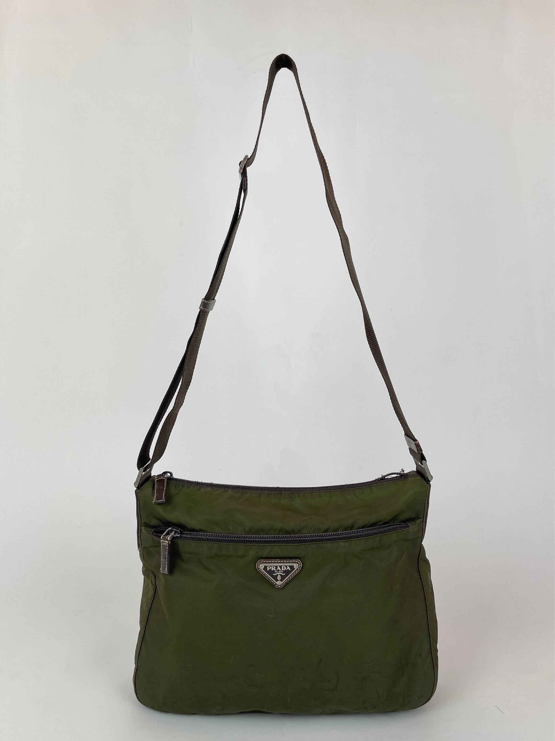 Green Prada nylon crossbody bag with adjustable strap and minimalist design, showcasing a sleek, modern accessory.