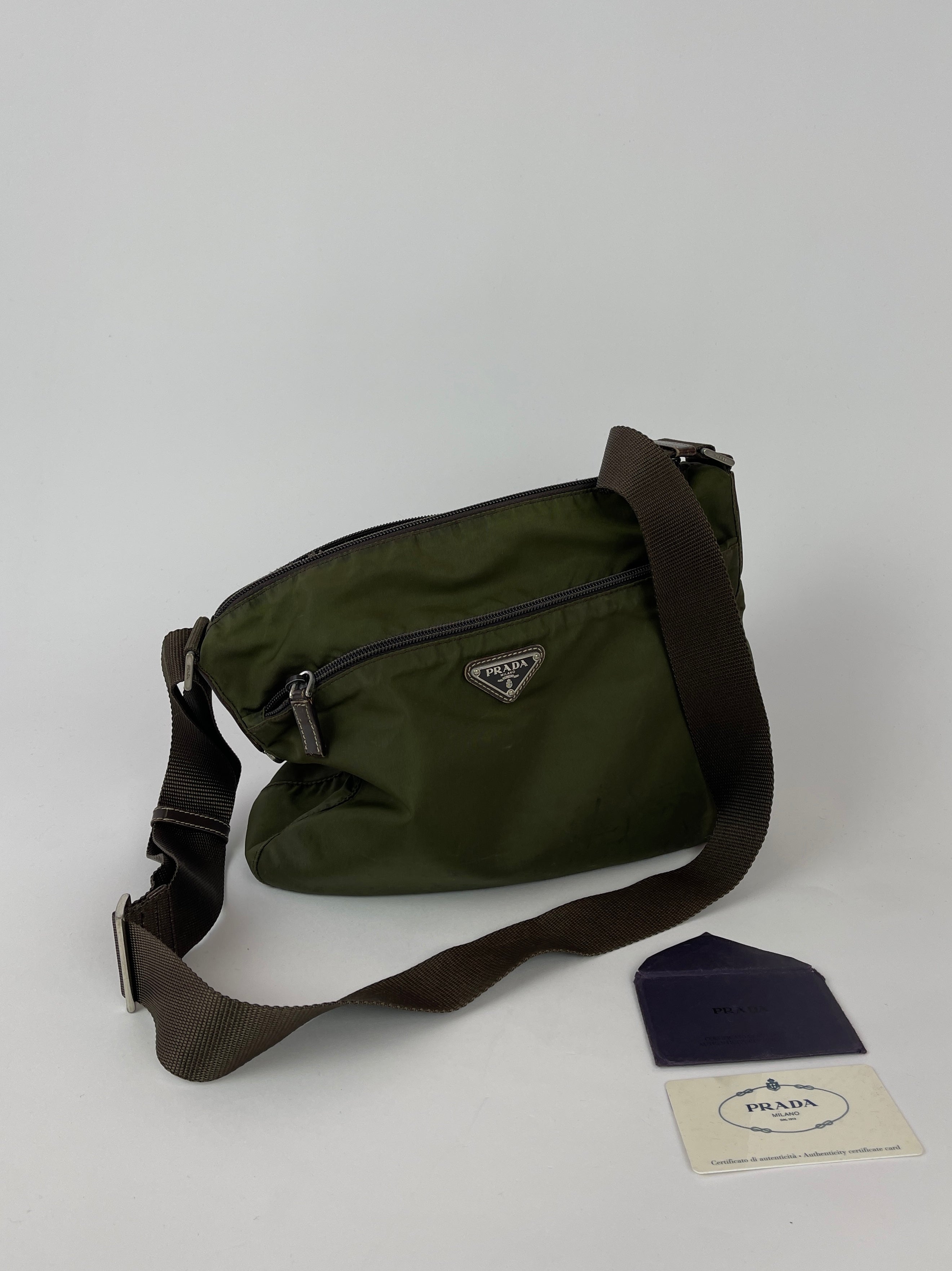 Green Prada nylon crossbody bag with adjustable strap and sleek design, featuring the Prada logo on the front.