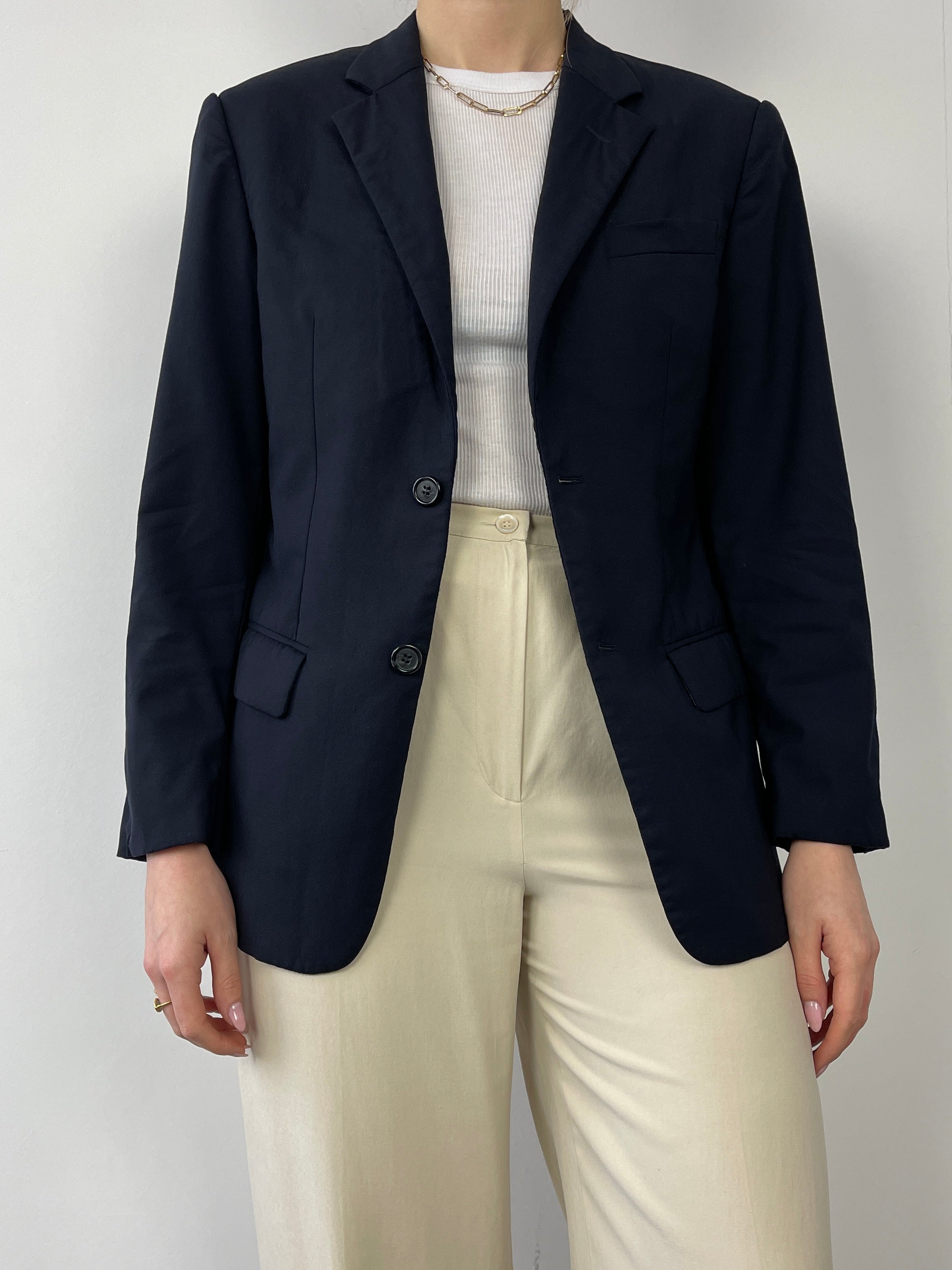 Navy Prada single-breasted tailored blazer shown on a hanger with structured lapels and sleek fit, ideal for formal or business wear.