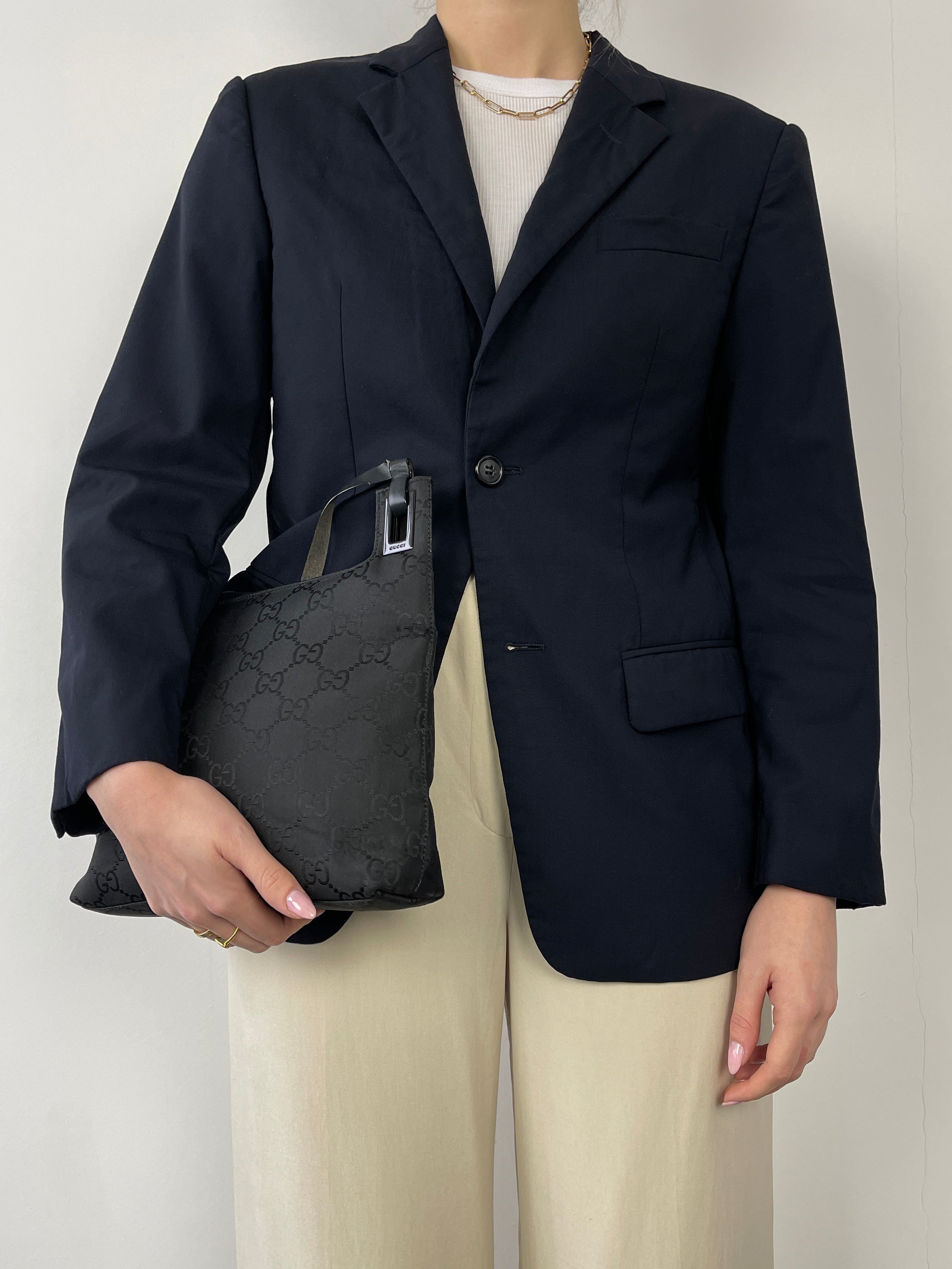 Navy Prada single-breasted tailored blazer with notch lapels and sleek fit, displayed on a hanger.