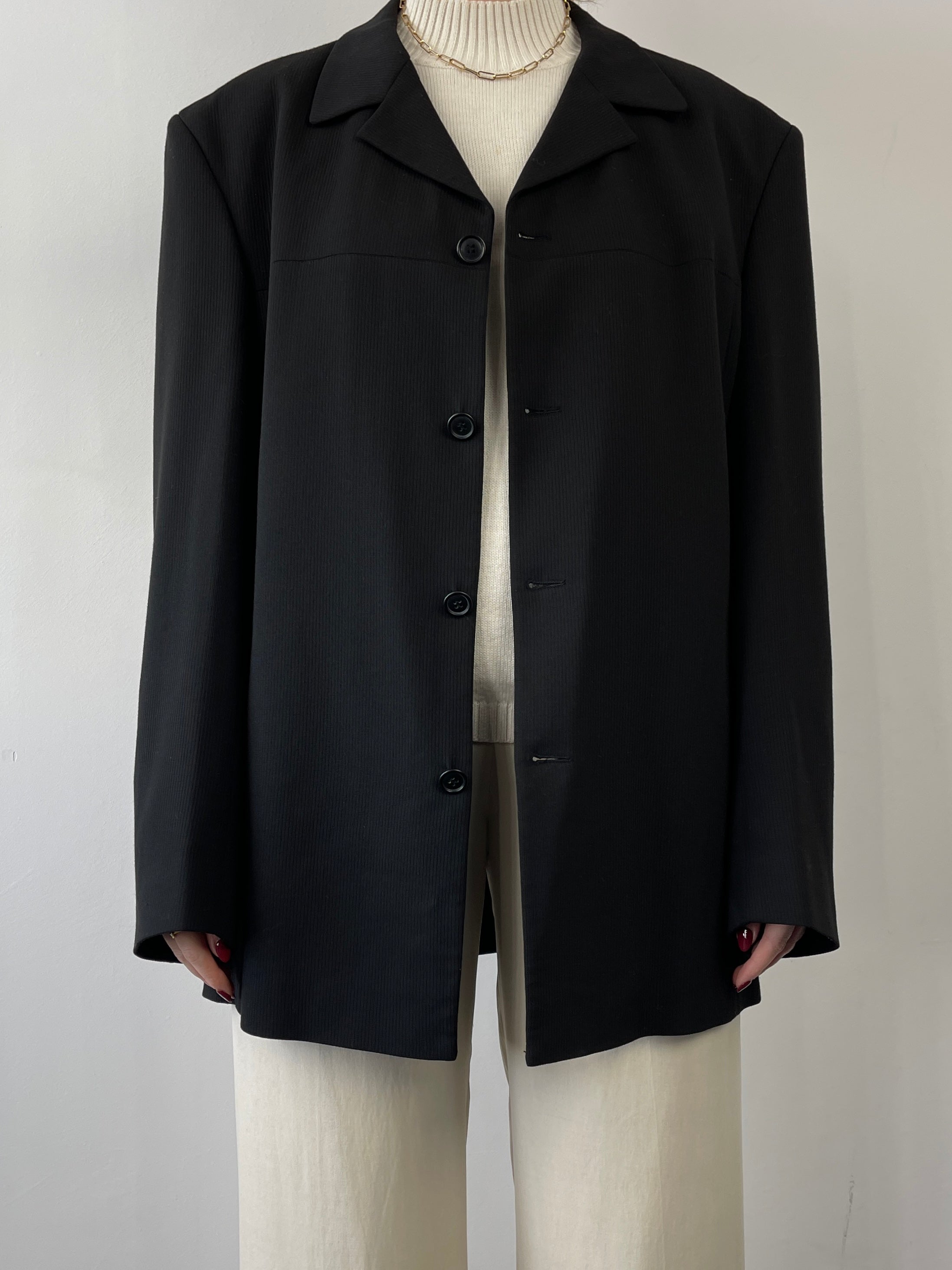 Black vintage relaxed blazer with a tailored fit, shown on a hanger, highlighting classic style and timeless design.