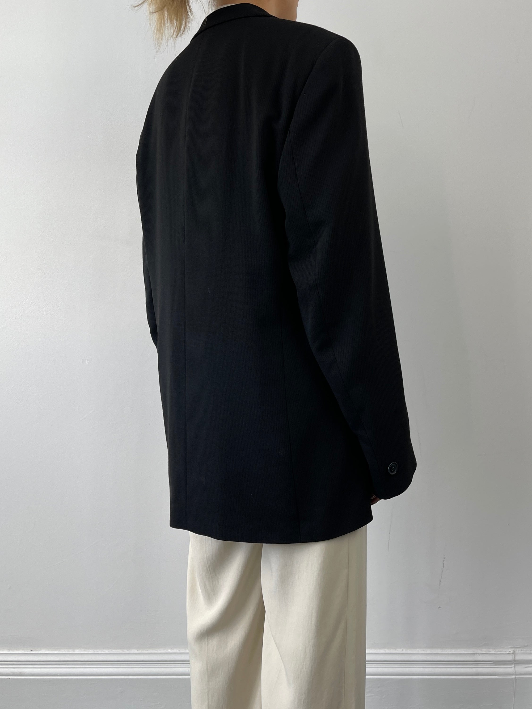 Black Vintage Relaxed Blazer from Vintage, featuring a classic tailored fit and casual style, displayed on a hanger.