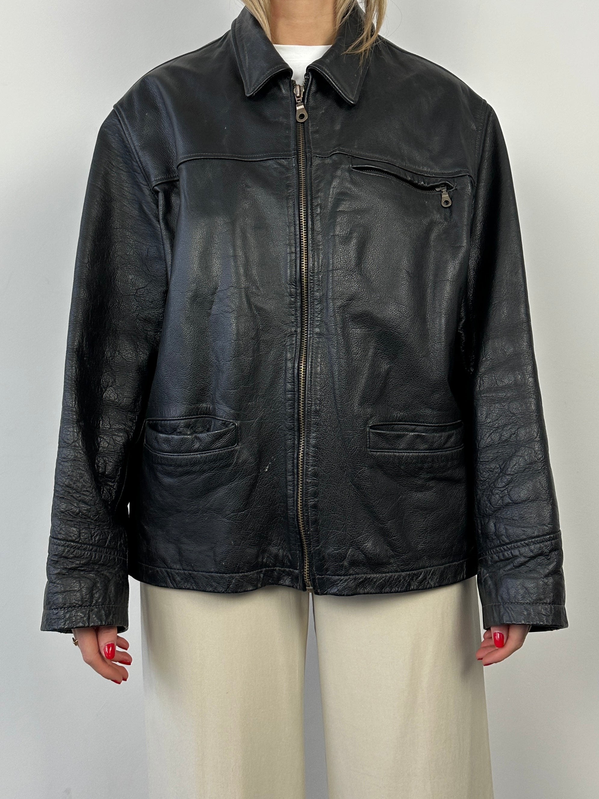 Black vintage boxy leather jacket with structured fit and classic design, shown on a hanger.