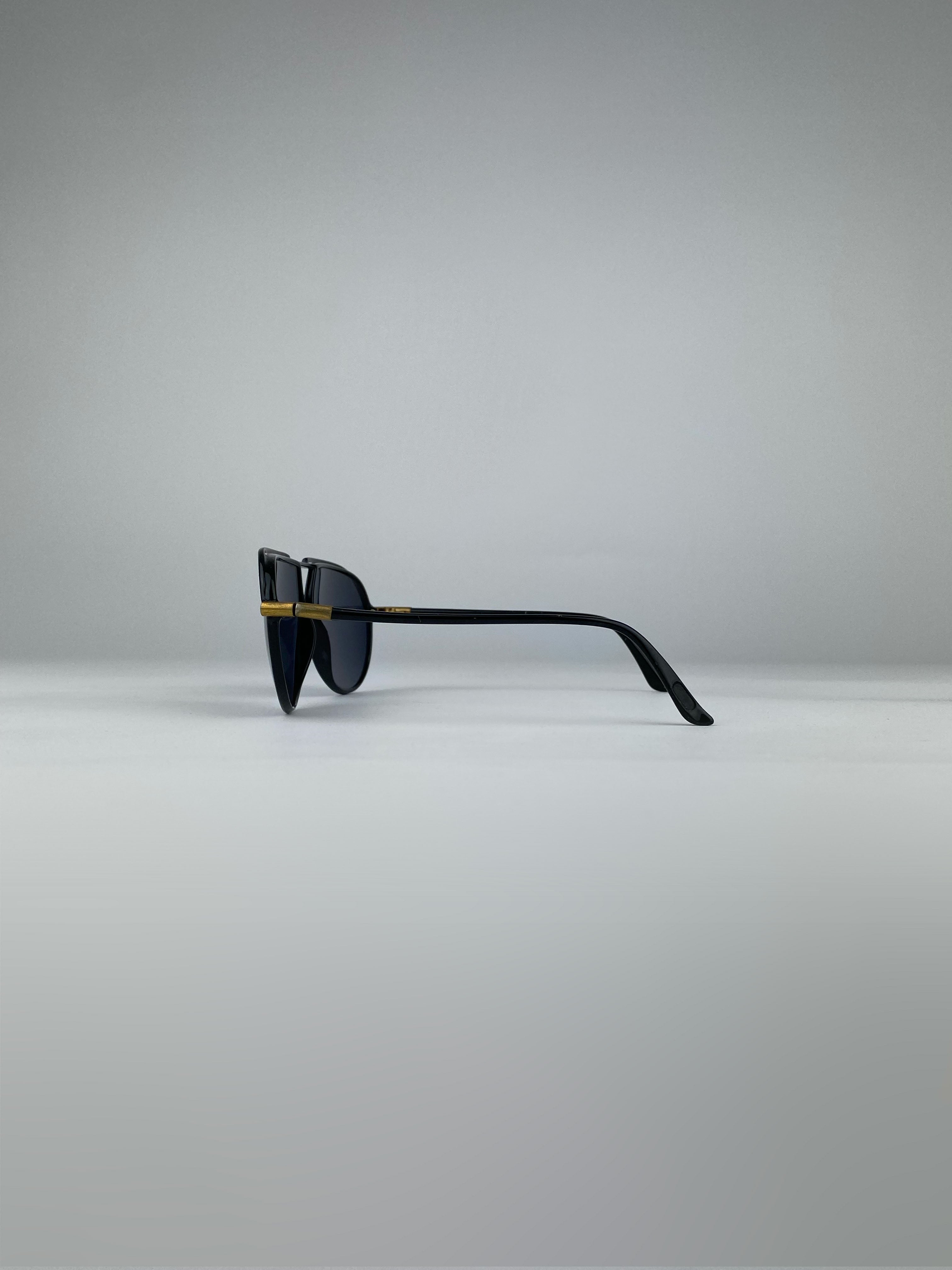 Black Yves Saint Laurent aviator sunglasses with metal frames and dark tinted lenses.